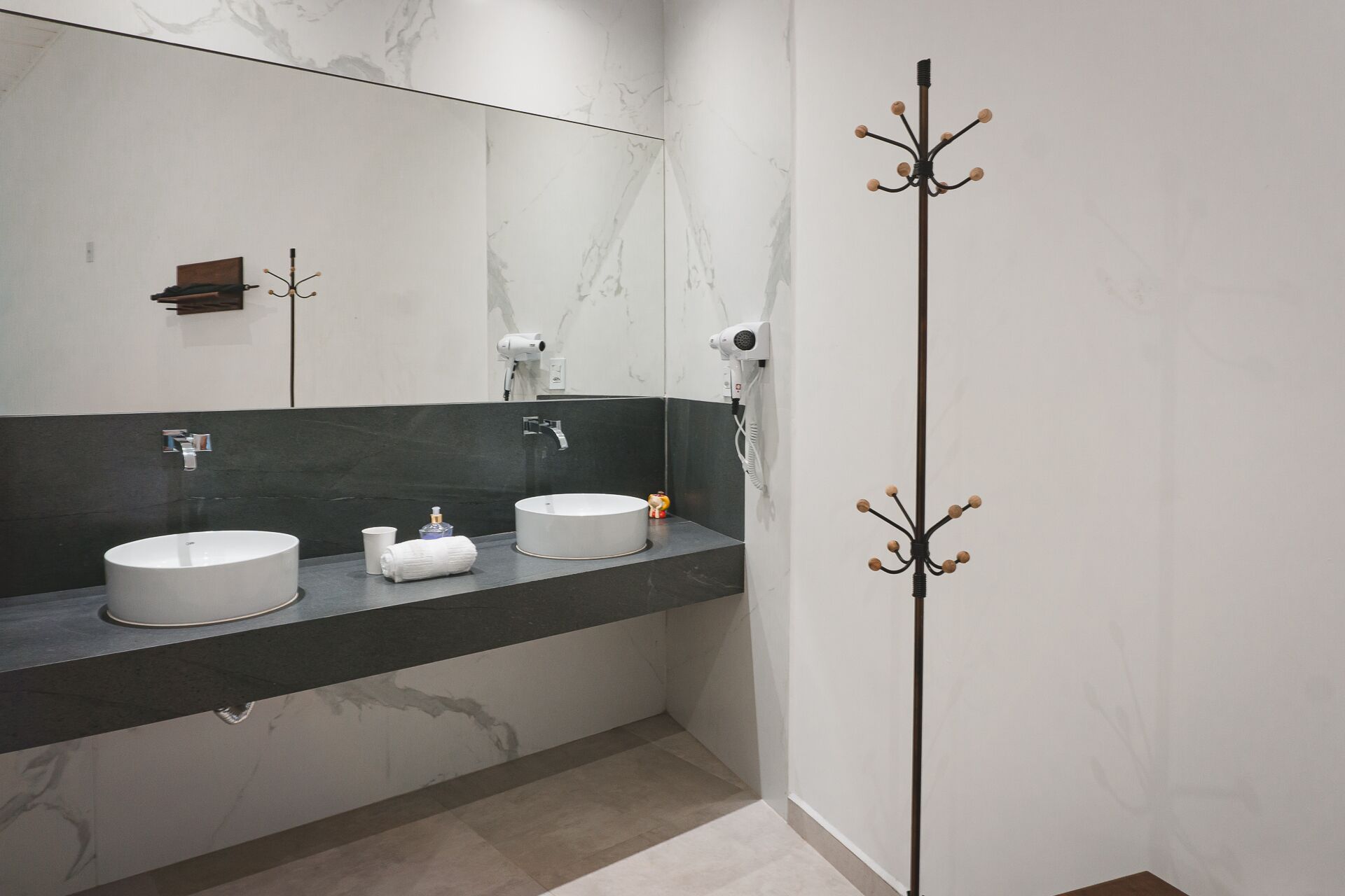 Une salle de bain moderne avec deux lavabos, un sèche-cheveux et un porte-serviettes.
