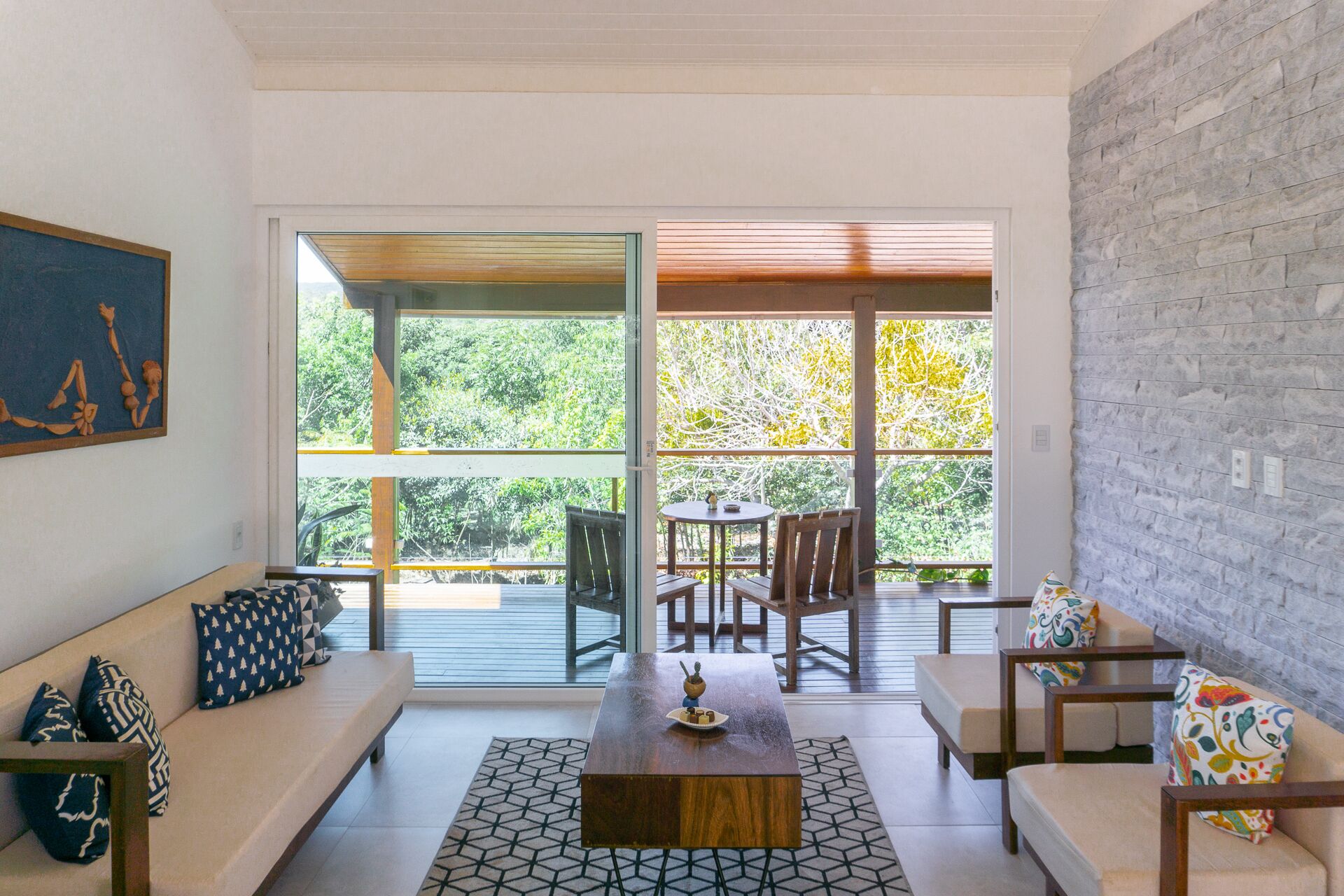 A modern living room with a sofa, a coffee table, and a dining area with chairs and a table.