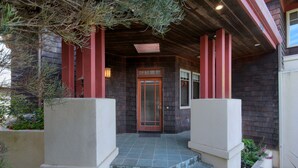 Een huis met een houten veranda, een voordeur en een klein raam.
