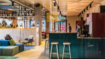 Un interior moderno con una zona de bar, asientos y una cocina.