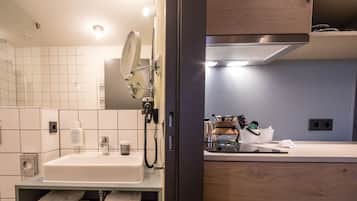 A modern bathroom with a white sink, mirror, and towel rack.