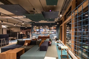 A modern interior with a seating area, a kitchen, and a wall decorated with framed photos.