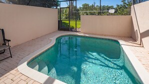 A rectangular indoor swimming pool with clear water, surrounded by a tiled floor and walls. - Windsor Palms-ru1025 (Kissimmee)