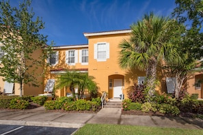 A two-story building with a yellow facade, white shutters, and a number '140' on the front. - Terra Verde-ru941 (Kissimmee)
