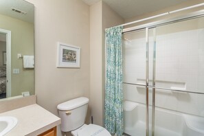 A bathroom with a toilet, sink, and glass shower enclosure. - Emerald Island-ru1029 (Kissimmee)