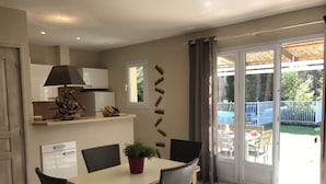 A dining area with a table, chairs, and a potted plant.