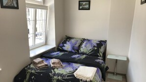 A small, compact room with a bed, a bedside table, and a window. - Gdańskie Apartamenty Targ Rybny Mołtawa (Gdansk)