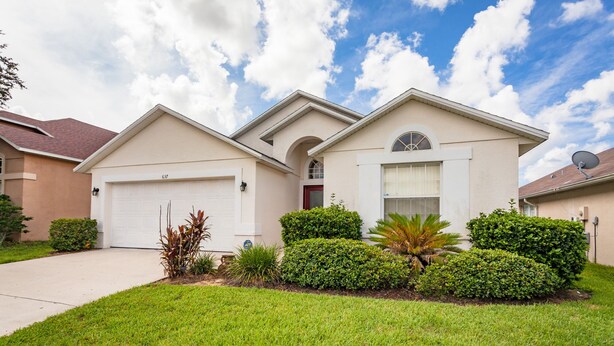 A two-story house with a garage, a satellite dish, and well-maintained landscaping. - Four Corners-ru942 (Davenport)
