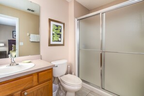 Une salle de bain équipée d’un lavabo, de toilettes et d’une douche à parois en verre.