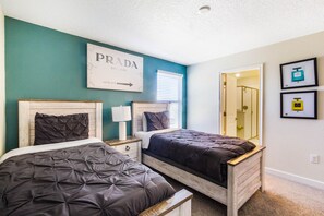 Une chambre avec deux lits, un miroir et un panneau fixé au mur.