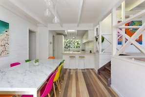 A modern kitchen with white cabinetry, a marble countertop, and colorful chairs. - At Agnes Ave Blairgowrie (Blairgowrie)