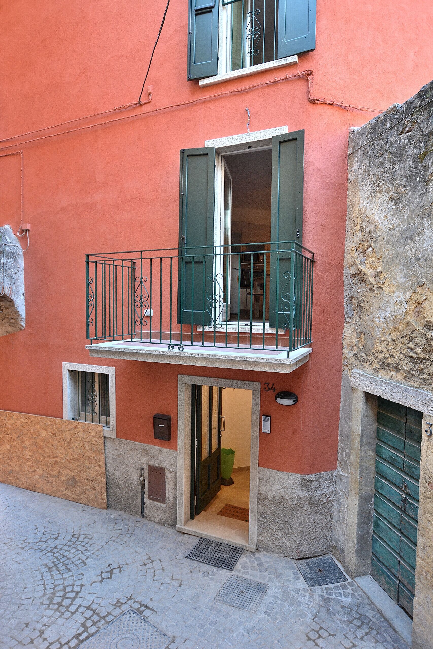A building with a balcony, a door, and a window.
