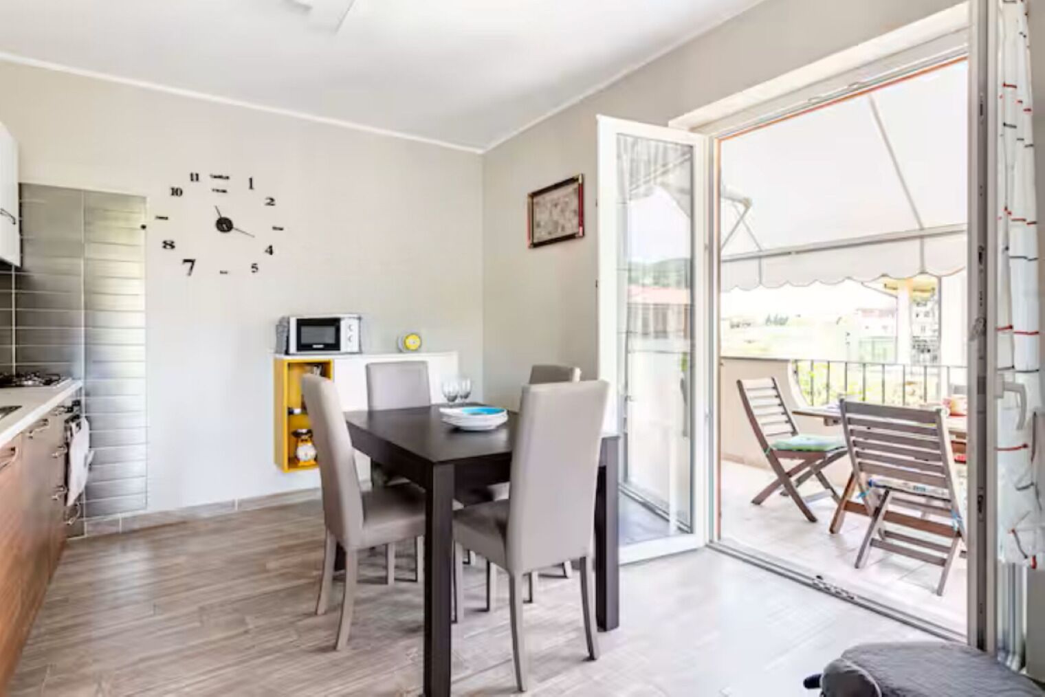 Un comedor con una mesa, sillas y un reloj en la pared.