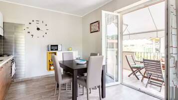 Un comedor con una mesa, sillas y un reloj en la pared.