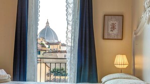 A bedroom with a bed, a window with curtains, a lamp, and a framed picture on the wall. - Great View San Marco - historic center of Florence (Firenze)