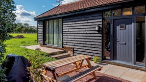 A wooden cabin with a tiled roof, large windows, and a door. - 1 bedroom accommodation in Raydon near Ipswich (Raydon near Ipswich)