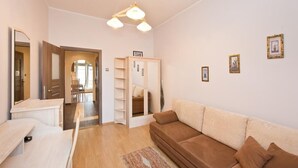 Un salon avec un canapé marron, un meuble en bois et un miroir.