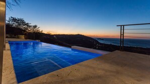 A swimming pool with a view of the ocean at sunset. - Casa de la Paz (Sardinal)