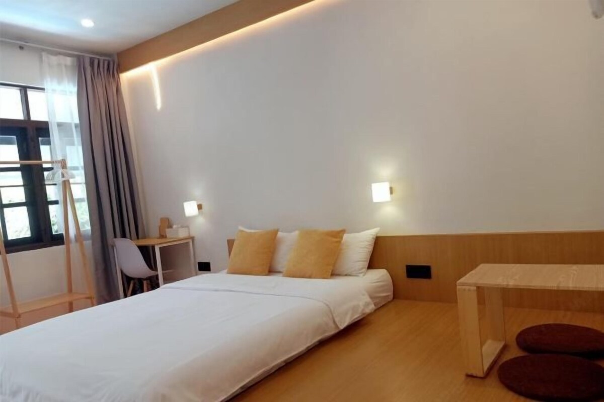 Een moderne hotelkamer met een groot bed, een bureau en een stoel.