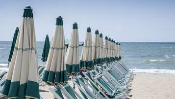 Playa privada, playa de arena blanca, camastros y sombrillas