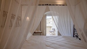 A bedroom with a bed, a chair, and a table. - L' Artiere Dimore nei Sassi (Matera)