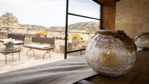 A clear view of a stone wall and a wooden bench outside a window. - L' Artiere Dimore nei Sassi (Matera)