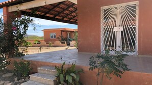 A covered patio area with steps leading to a door with a white gate. - Full equipped bungalows with swimming pool, wifi, garden for 2 to 5 people (Morro)