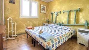 A bedroom with a bed, a nightstand, a dresser, a window, and a wall-mounted rack. - Terrazza 1 - BB La Traja (Gagliano del Capo)