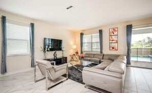 A modern living room with a sofa, TV, and decorative items.