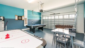 Une pièce équipée d’une table de billard, d’un baby-foot, d’un jeu de fléchettes et d’une table de snooker.