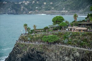 A coastal cliff with a viewing platform, overlooking the sea and a town in the background. - Il Baluardo Sea View Apartment on the Cliff (Manarola)