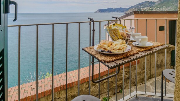 Ein Balkon mit Frühstückstisch und Blick auf das Meer.
