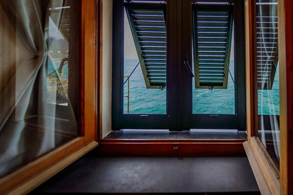 A room with a view of the sea through open shutters. - Il Baluardo Sea View Apartment on the Cliff (Manarola)