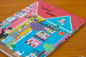 A colorful guest book with illustrations of various scenes and the text "CINQUE TERRE RIVER" visible. - Il Baluardo Sea View Apartment on the Cliff (Manarola)