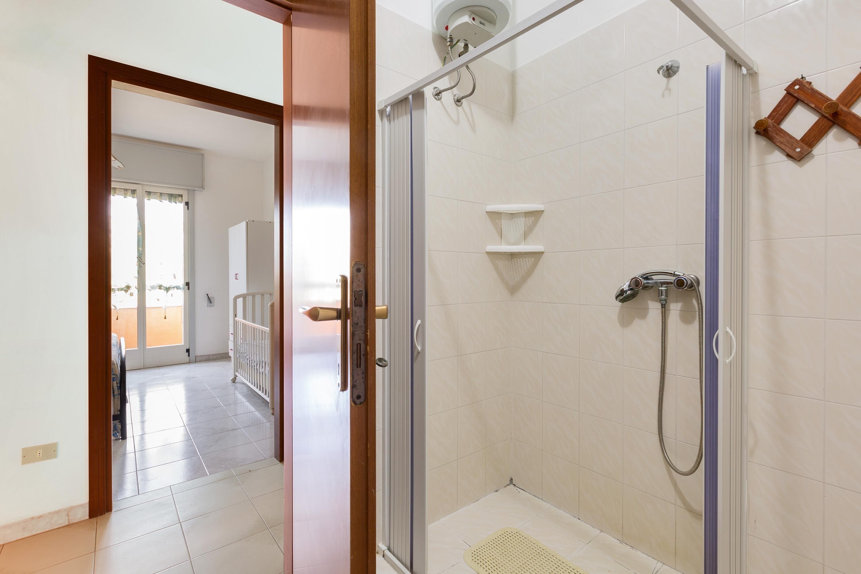A bathroom with a glass shower enclosure, a toilet, and a sink.