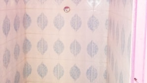 Esquina de una habitación con paredes rosas y baldosas estampadas.