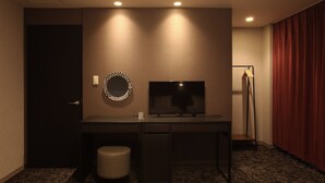 A hotel room with a desk, a television, a small stool, and a red curtain. - Kujo no Yado Great House Osaka (Osaka)