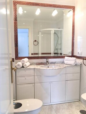 Een douche, een haardroger, een bidet, handdoeken