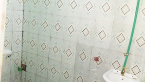 A bathroom with a toilet, sink, and shower area. - Riverside Tourism Guest House (Embu)