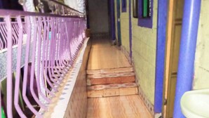 A narrow corridor with tiled flooring, a metal railing, and a staircase leading to a door. - Riverside Tourism Guest House (Embu)