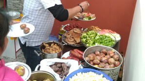 Buffet com diversos pratos, incluindo carnes, vegetais e batatas.