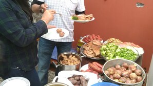 Buffet com diversos pratos, incluindo carnes, batatas e legumes.