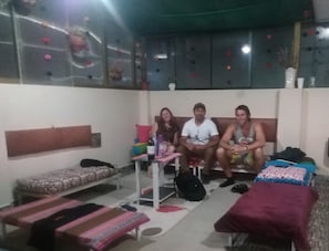Una habitación con sofá, una mesita, un banco y una cama.