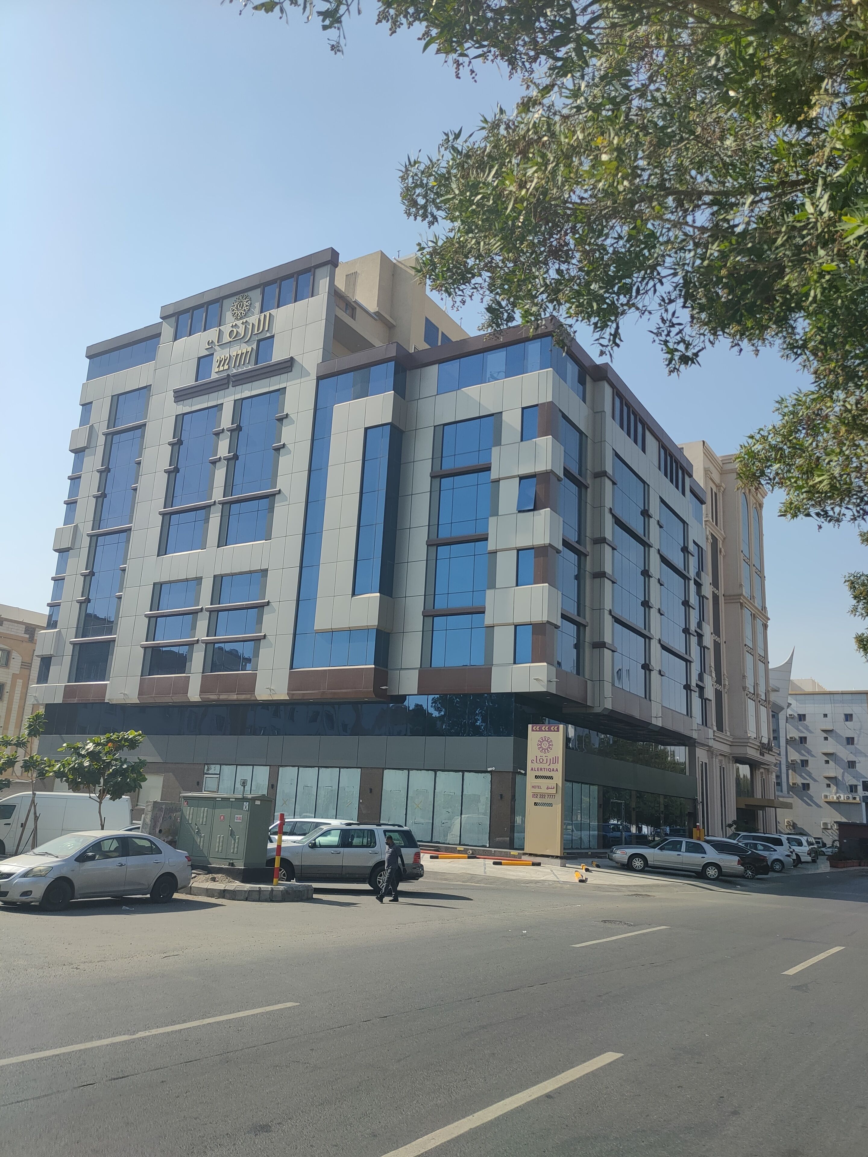 Um edifício moderno de vários andares, com entrada destacada e grandes janelas.