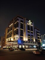 A multi-story hotel with illuminated signage and a modern architectural design.