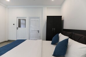 A hotel room with a bed, a wardrobe, and a door. - Villacork (Galle)