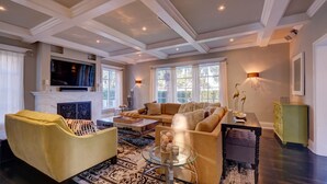 A spacious living room with a fireplace, comfortable seating, and large windows. - 4/6bd SPACIOUS, Heart of Miami Beach! Mediterranean Villa w/Jacuzzi, HUGE YARD! (Miami Beach)