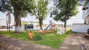 A playground with slides and swings, a mailbox, and a caution sign. - Current River Inn (Van Buren)