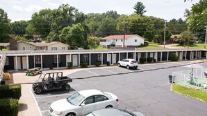 A motel with a parking lot, a covered picnic area, and a row of rooms with individual entrances. - Current River Inn (Van Buren)