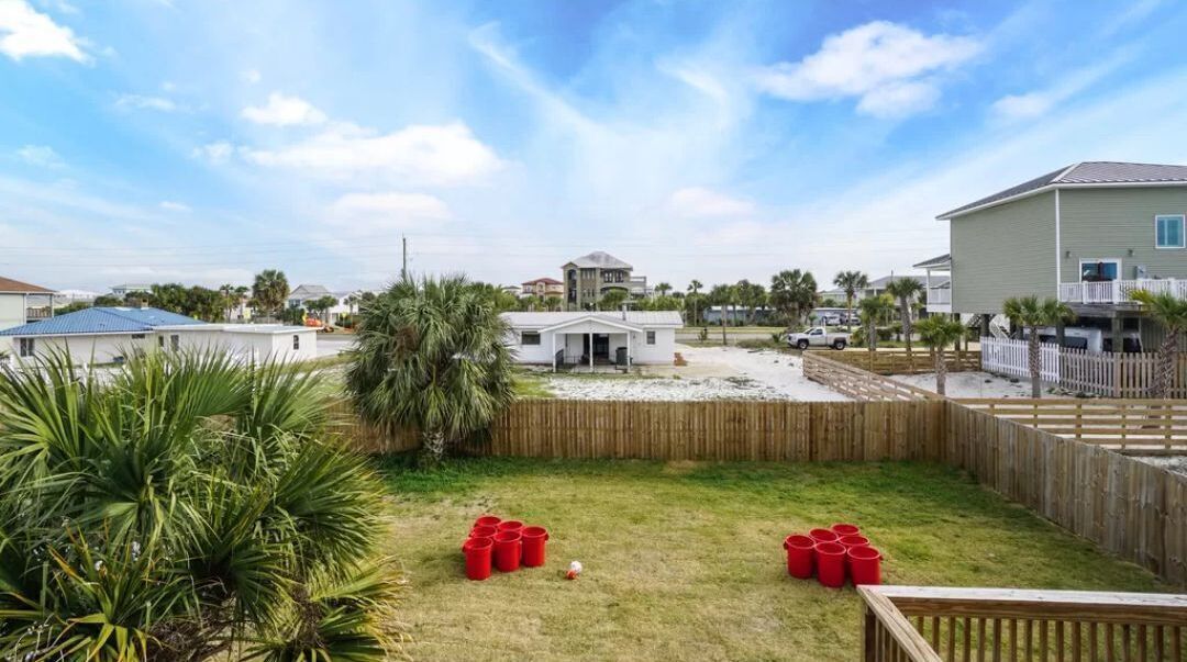 Zona residencial con casas, patio cercado y cielo despejado.